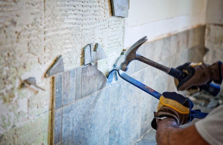 operaio che elimina le piastrelle dalla cucina