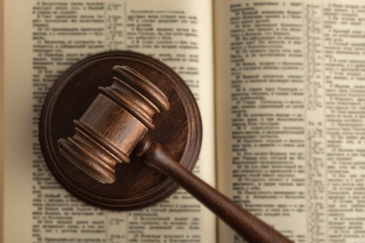 Un libro di legge con sopra un martello da giudice