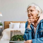 nonna che riflette con lo sfondo di una camera da letto moderna