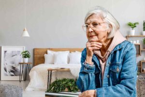 nonna che riflette con lo sfondo di una camera da letto moderna