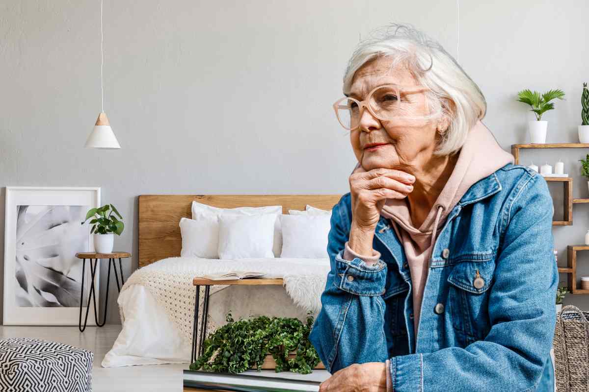 nonna che riflette con lo sfondo di una camera da letto moderna