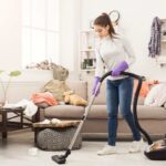 donna che pulisce casa con aspirapolvere