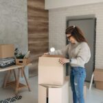 donna che sistema degli scatoloni in casa dopo un trasloco