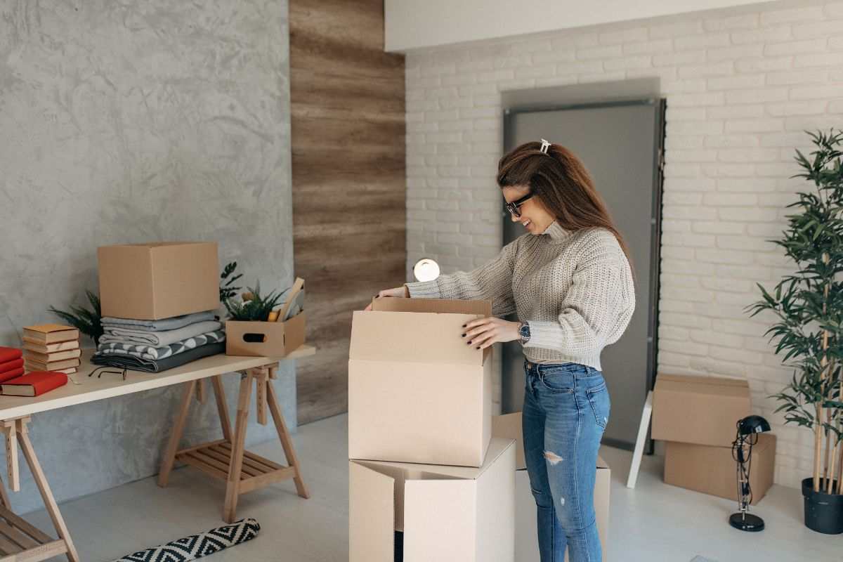 donna che sistema degli scatoloni in casa dopo un trasloco