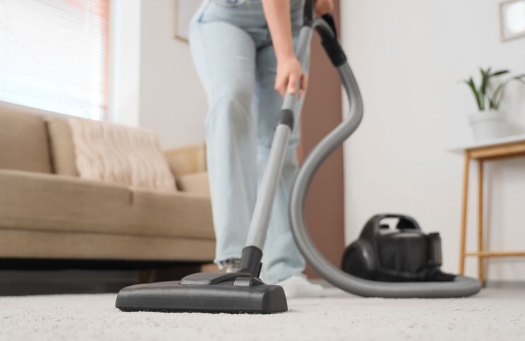 donna passa aspirapolvere sul tappeto