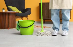 donna con mocio e secchio per lavare il pavimento