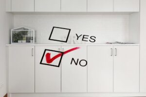 cucina con mobili bianchi su cui c'è scritto si o no