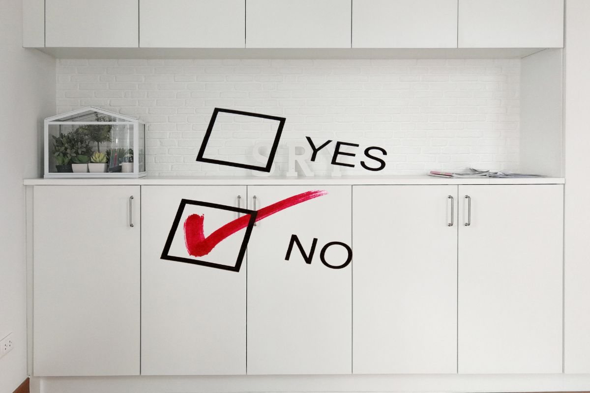 cucina con mobili bianchi su cui c'è scritto si o no