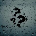 Un muro con sopra della condensa e dei punti interrogativi centrali