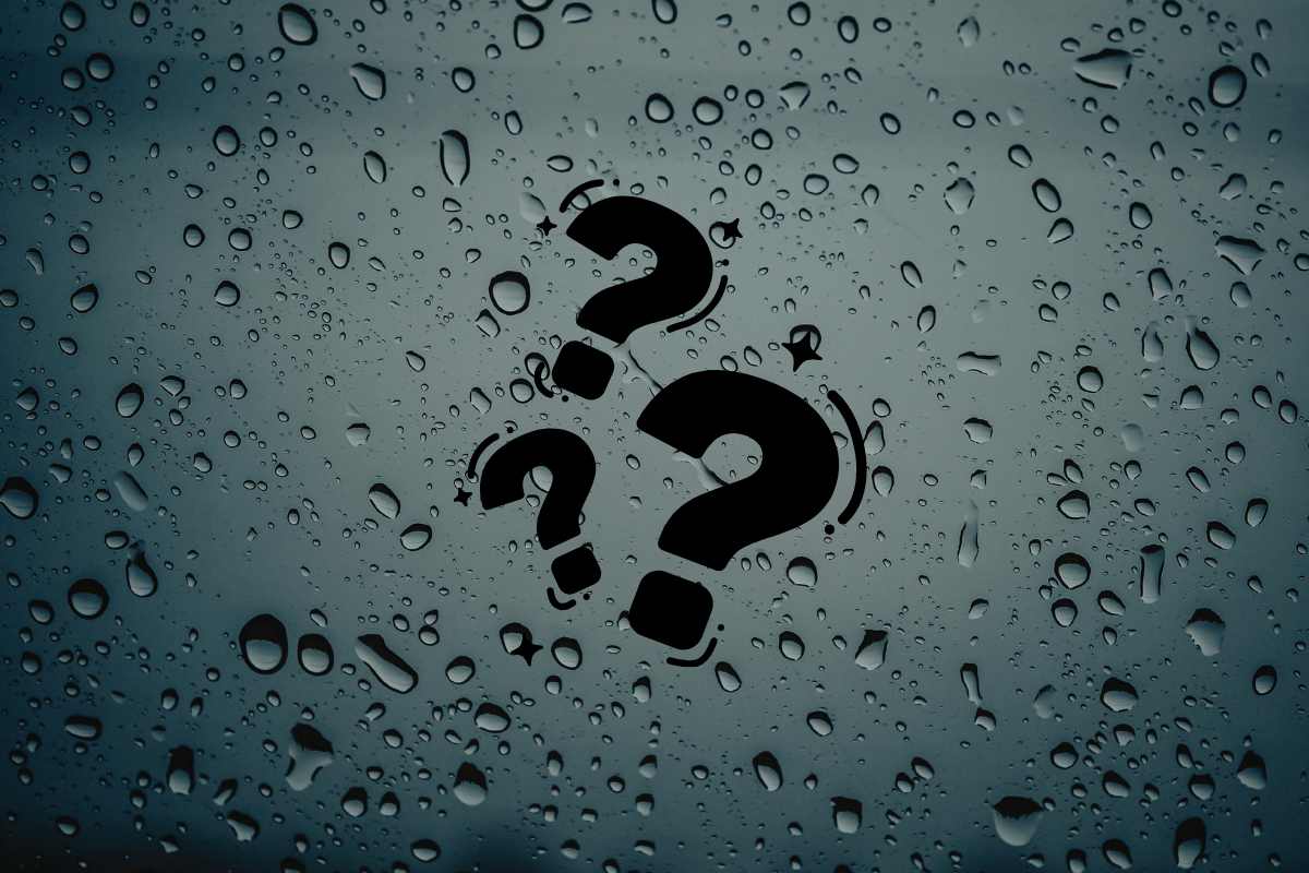 Un muro con sopra della condensa e dei punti interrogativi centrali