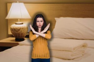 camera da letto con lampada da tavola su comodino e donna che fa no con le braccia