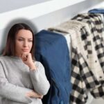 donna che pensa e sfondo in cui si vede un termosifone con dei vestiti da asciugare sopra