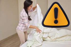 donna che rifa il letto e simbolo di pericolo in giallo