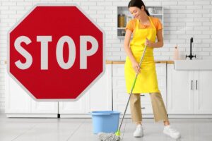 donna che pulisce il pavimento con secchio e scritta grande stop