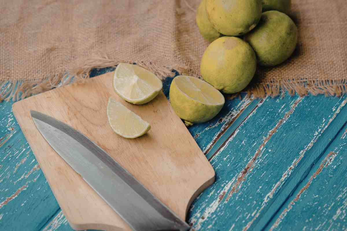 tagliere con coltello vicino e dei limoni 
