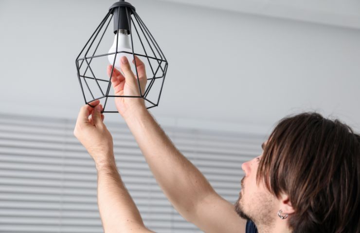 uomo che monta una lampada