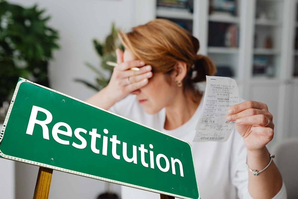 donna con foglio in mano e mano su occhio con cartello verde e scritto restituzione