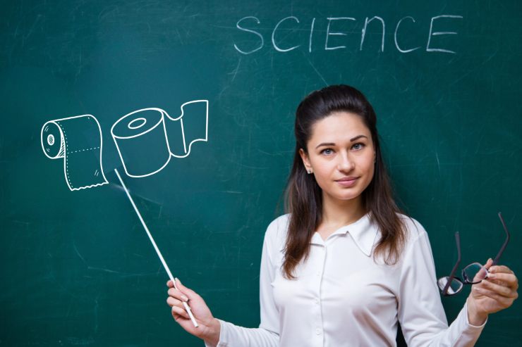 Una scienziata che indica su una lavagna due disegni di carta igienica