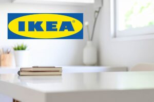 scrivania bianca con libro adagiato sopra e logo ikea