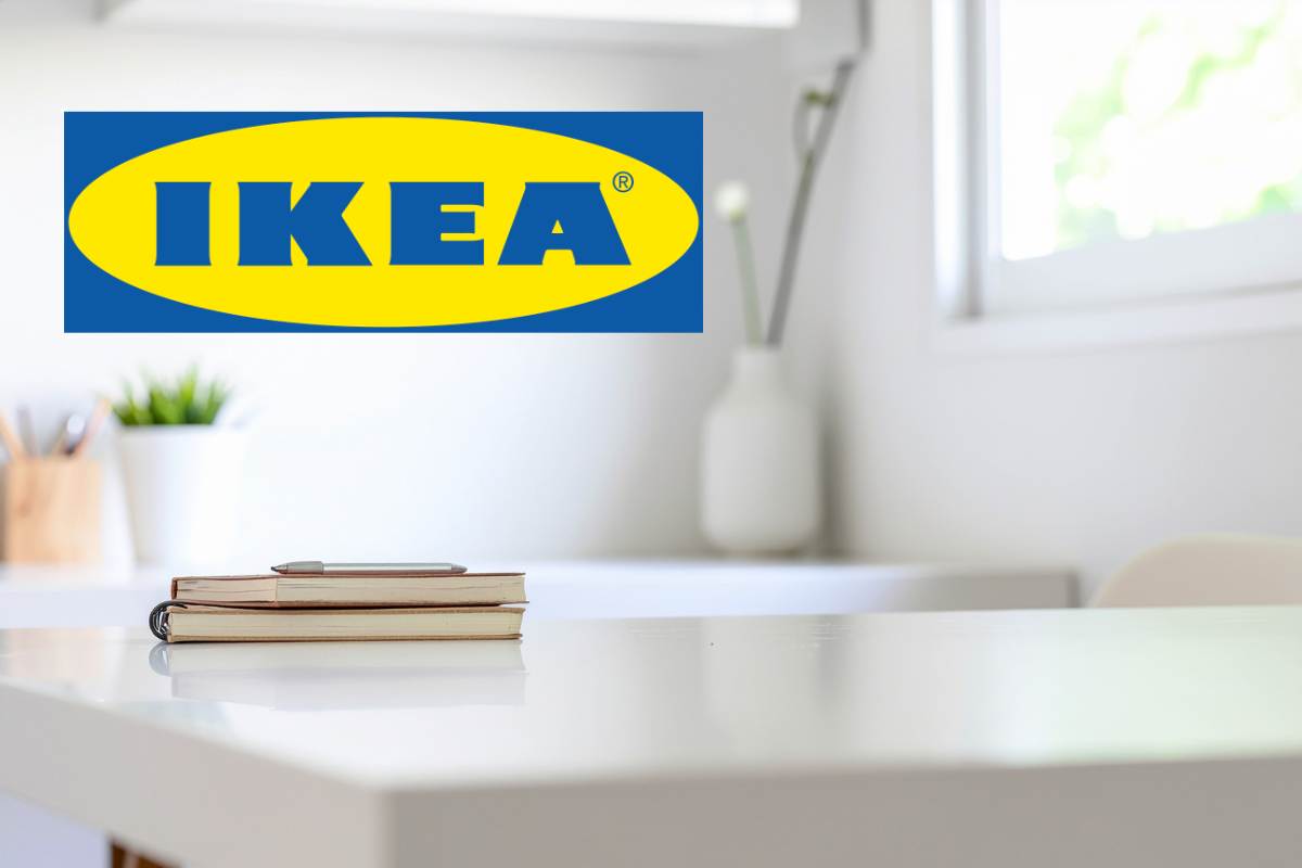 scrivania bianca con libro adagiato sopra e logo ikea