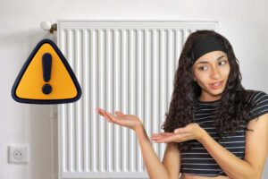 termosifone e donna che lo indica con simbolo di attenzione giallo