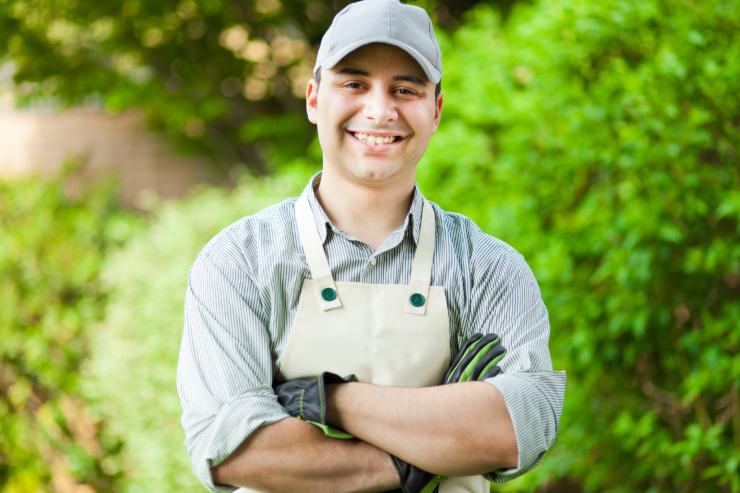 Un giardiniere in un giardino che è in posa per la foto