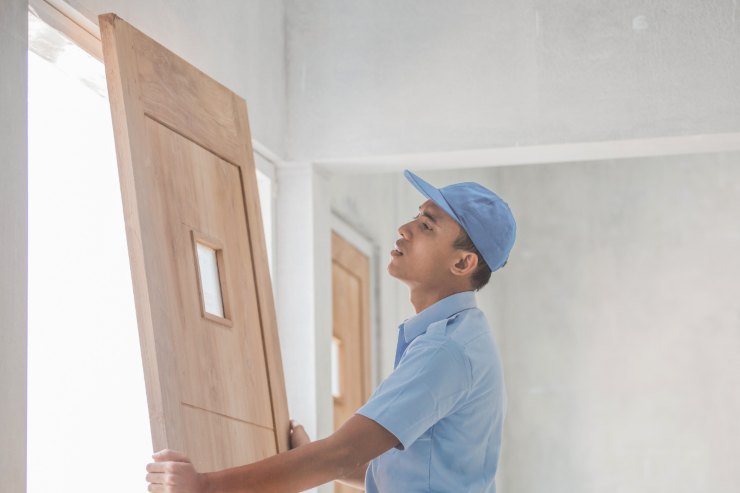 Un operaio che sta installando una porta