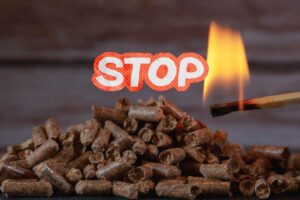 Del pellet che viene acceso con un fiammifero ed una scritta stop in primo piano