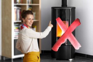 donna che indica una stufa a pellet in casa che ha una x rossa sopra