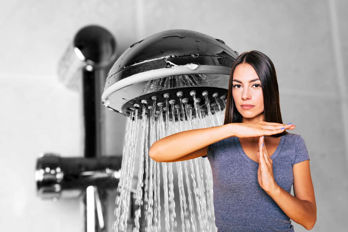 Soffione della doccia con acqua che scende e donna che da segno di stop
