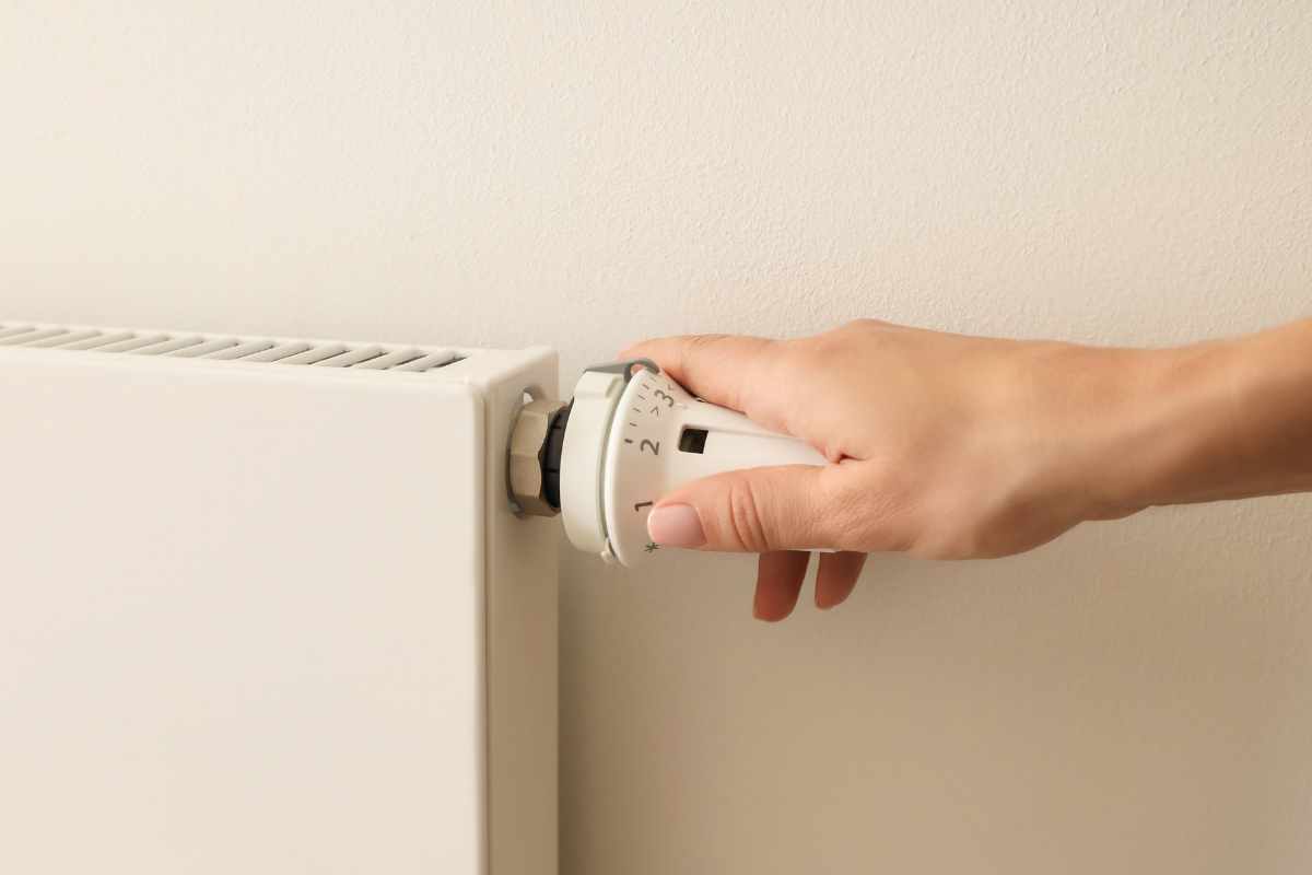 mano su manopola del termosifone