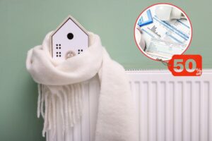 modellini di casa avvolto da una sciarpa messo su un termosifone e bollette con 50% di sconto