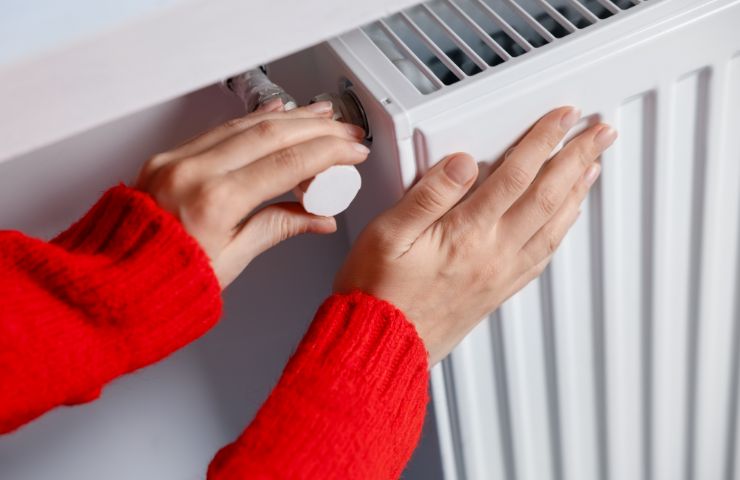 mani donna che toccano termosifoni