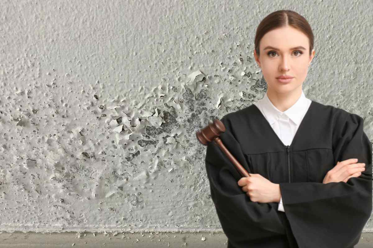 muro con segni di umidita e giudice con martelletto a mani incrociate