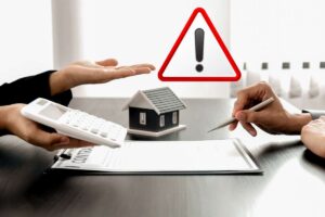 mani con fogli casa modellino vicino e simbolo attenzione