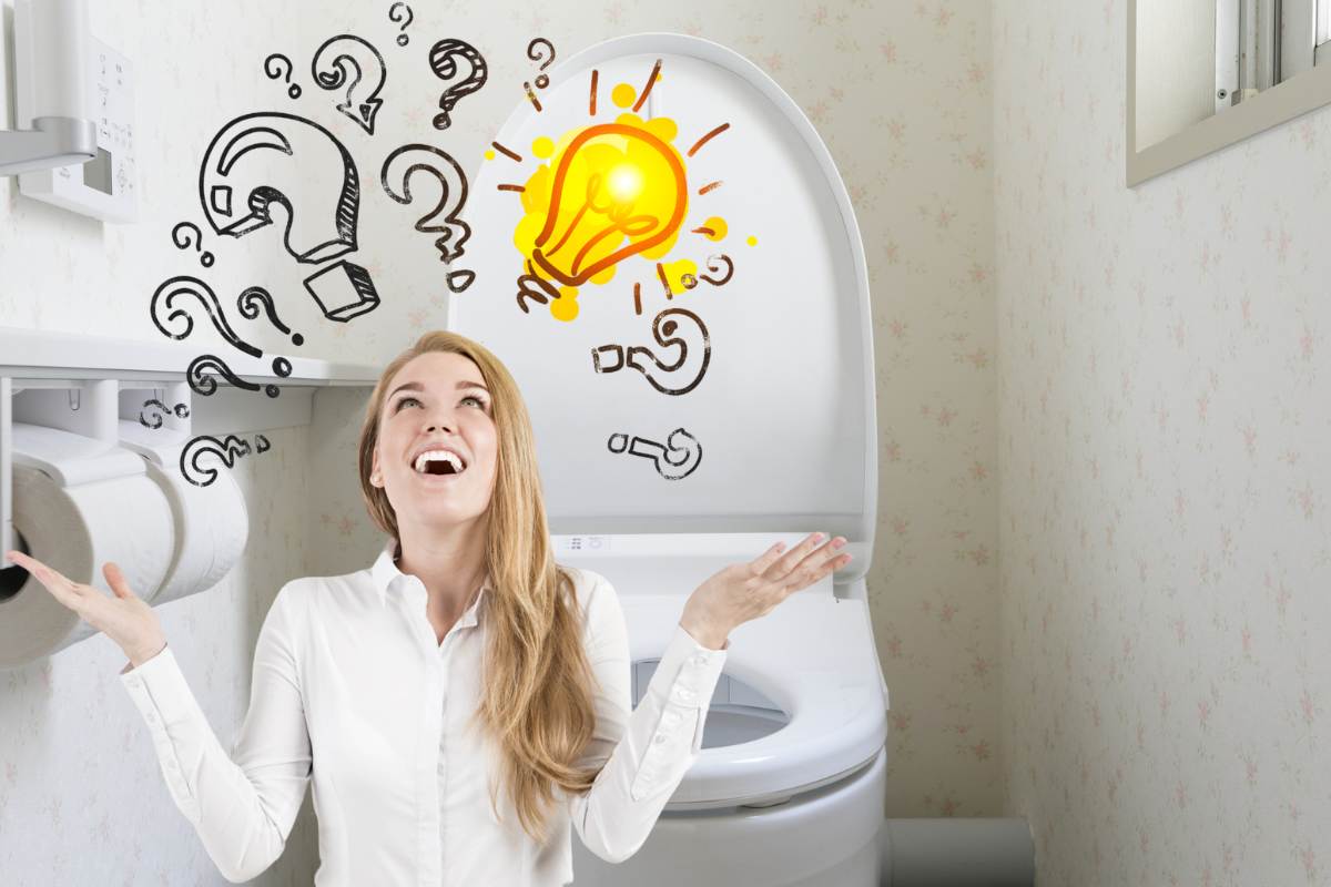 donna con mani aperte e lampadina con punti interrogativi con tavoletta bagno aperta