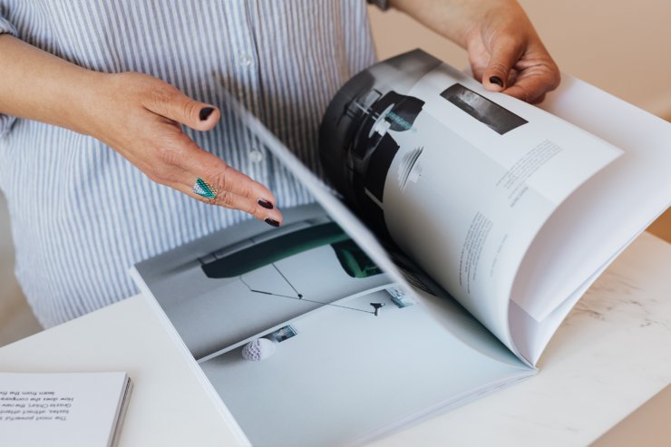 Una persona che sfoglia delle pagine di una rivista di design