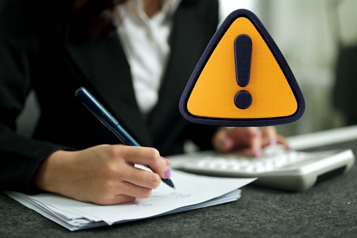 Donna che scrive su foglio e simbolo attenzione giallo