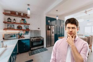Una persona dubbiosa che guarda l'arredo della sua cucina