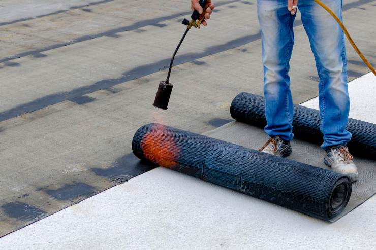 Un operaio che installa la guaina ardesiana