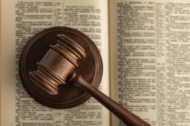 Un libro di legge con sopra un martello da giudice