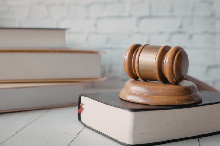 Dei libri di legge con sopra un martello da giudice