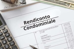Un rendiconto condominiale con sopra calcolatrice, soldi e penna