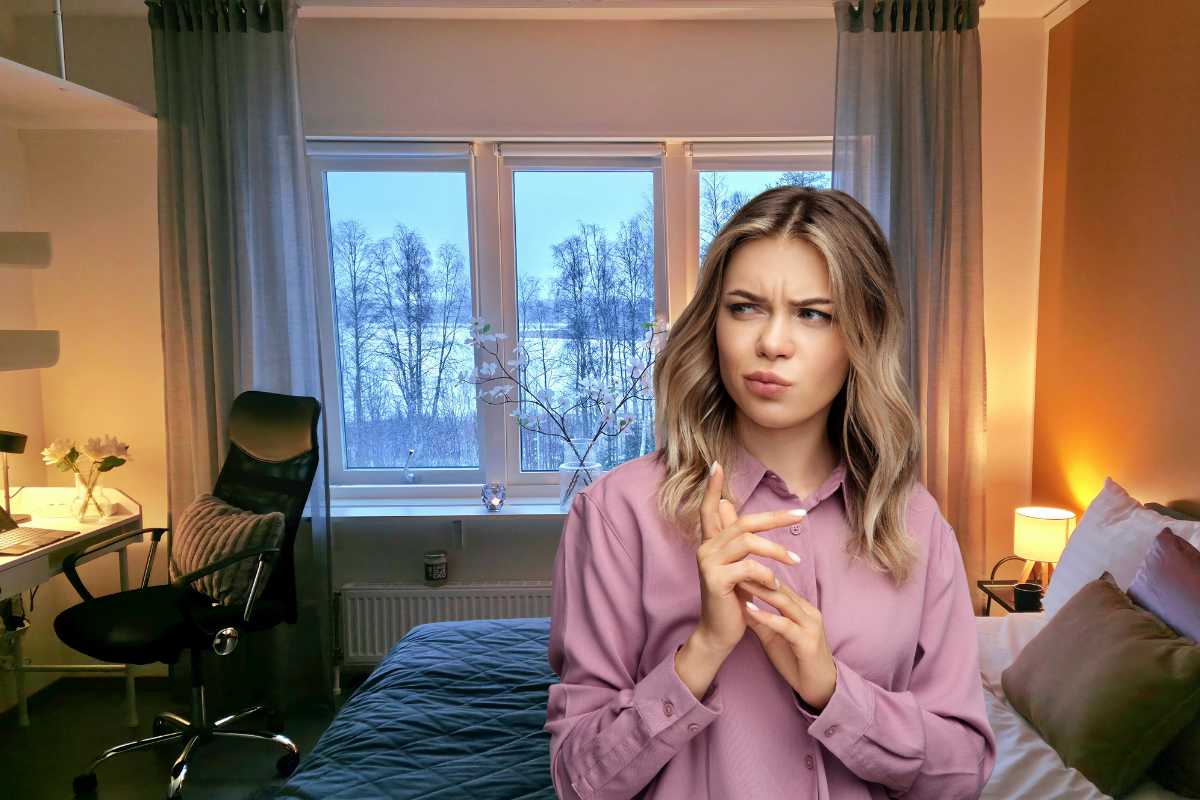 Una stanza da letto piccola ed una ragazza in primo piano contrariata