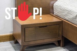 Un comodino accanto al letto con sopra una scritta "Stop".