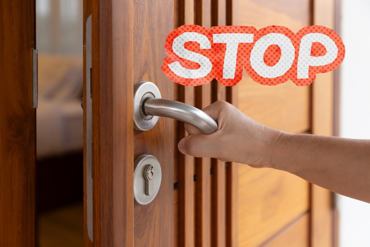 Una porta di legno con sopra una scritta di "stop"