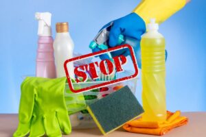 Diversi prodotti per la pulizia ed in primo piano una scritta di stop