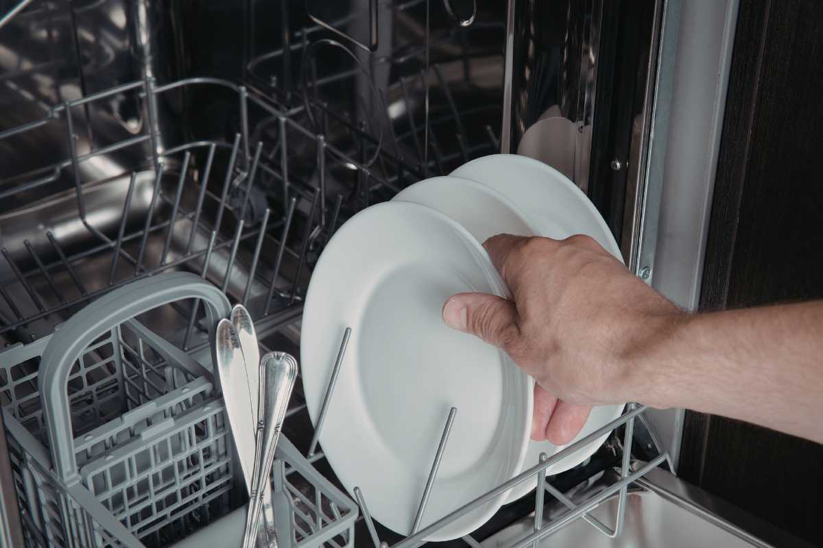 mano che carica lavastoviglie 