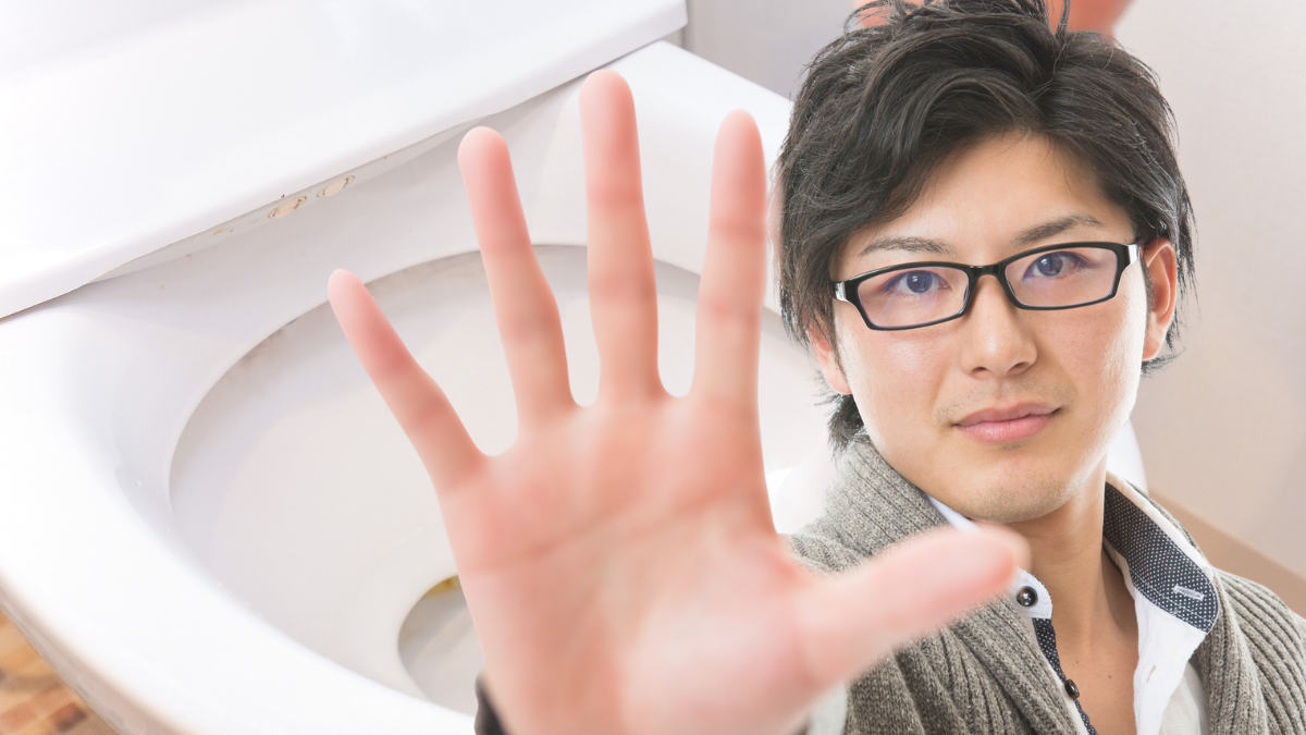 uomo che fa gesto con mano e bagno sullo sfondo