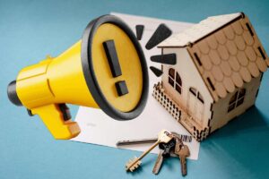 casa e chiavi con megafono giallo